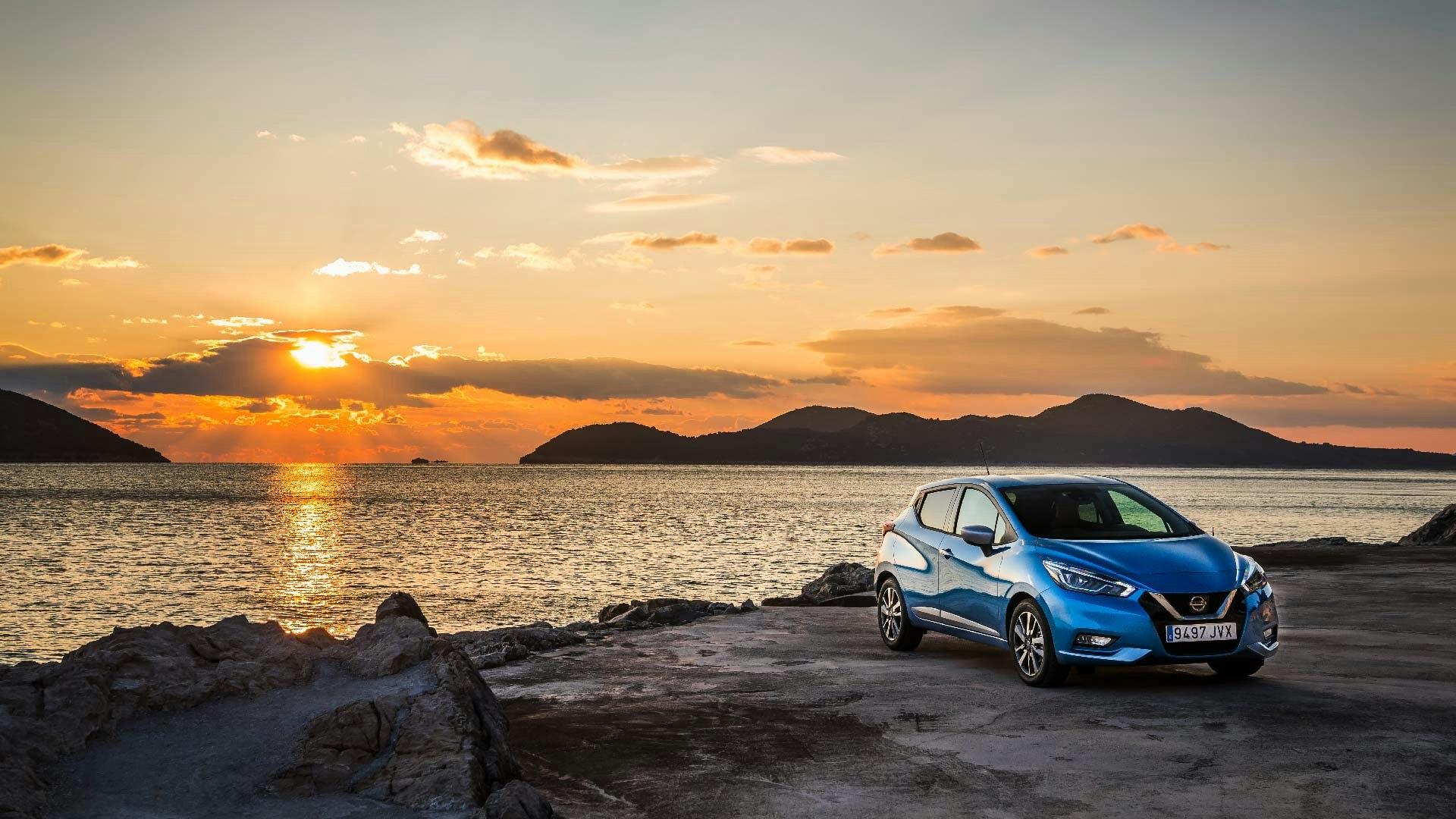 Nissan Micra i blå front parkeret med solnedgang