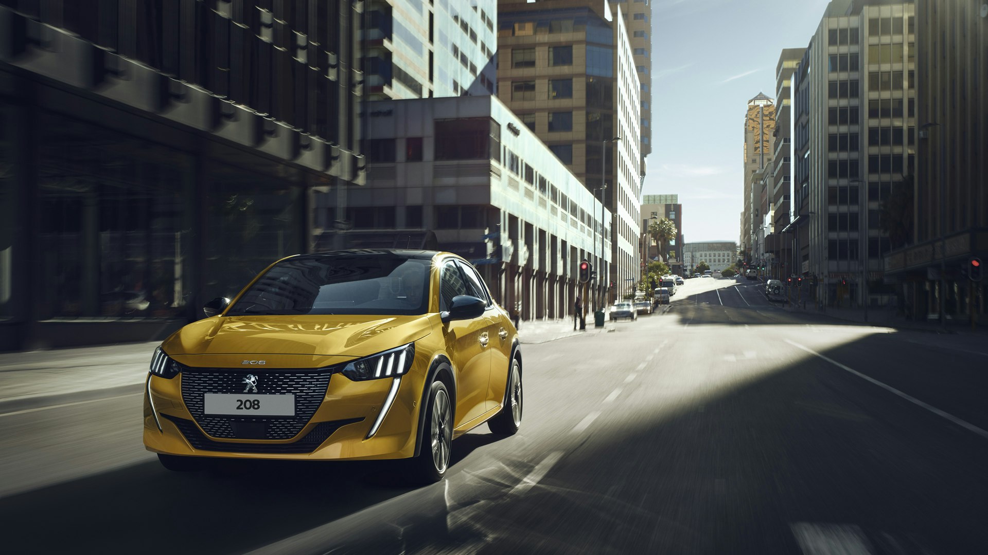Peugeot 208 kørende i byen i gul front